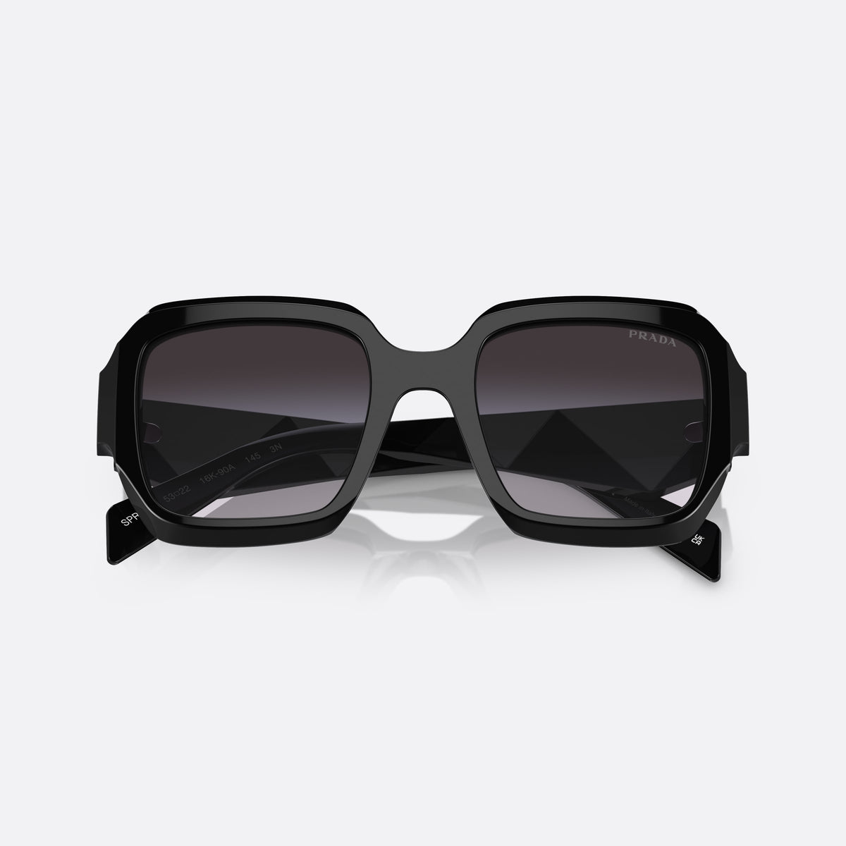 Prada PR 28ZS 16K-90A sunglasses, black pillow frame for women, plain double-arch bridge, brand lettering on the temples, folded