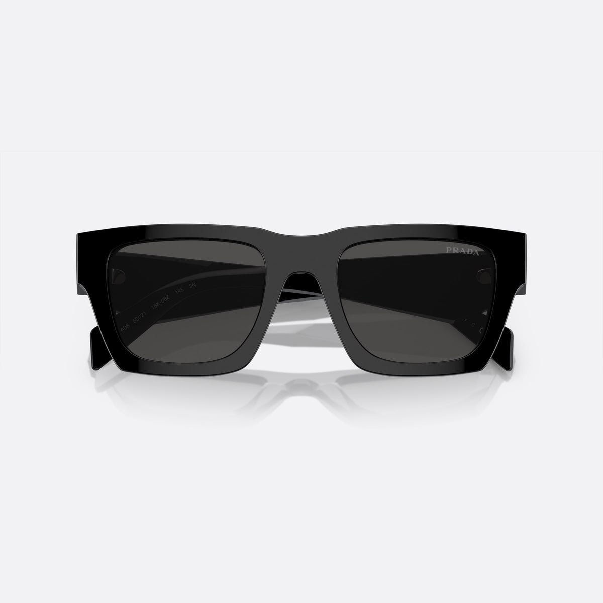 Prada PR A06S 16K-08Z B sunglasses, black pillow frame for men, plain solid bridge, brand logo on temple, folded