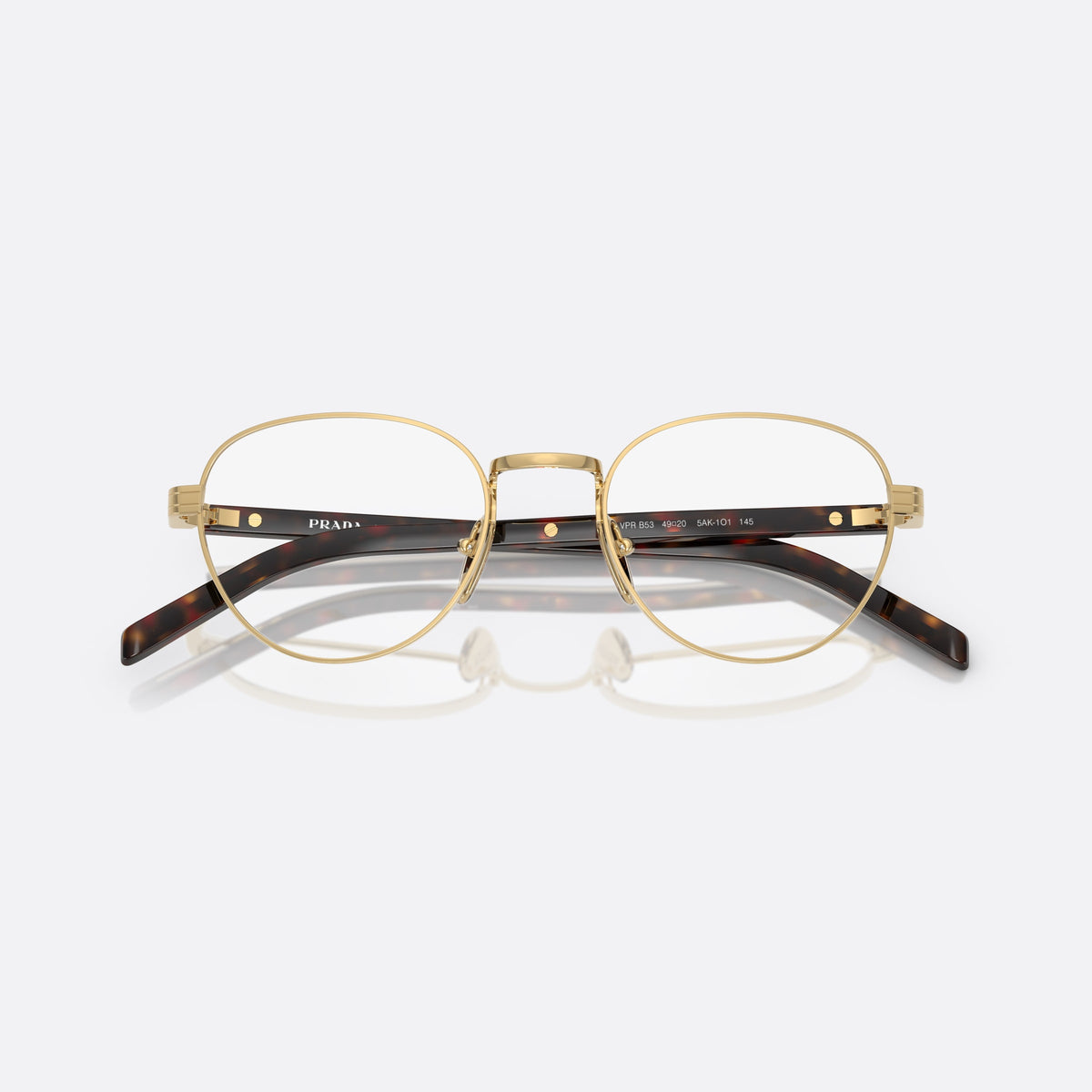 Prada PR B53V 5AK1O1 eyeglasses, gold round frame for women, plain metal bridge, brand lettering on temples, folded