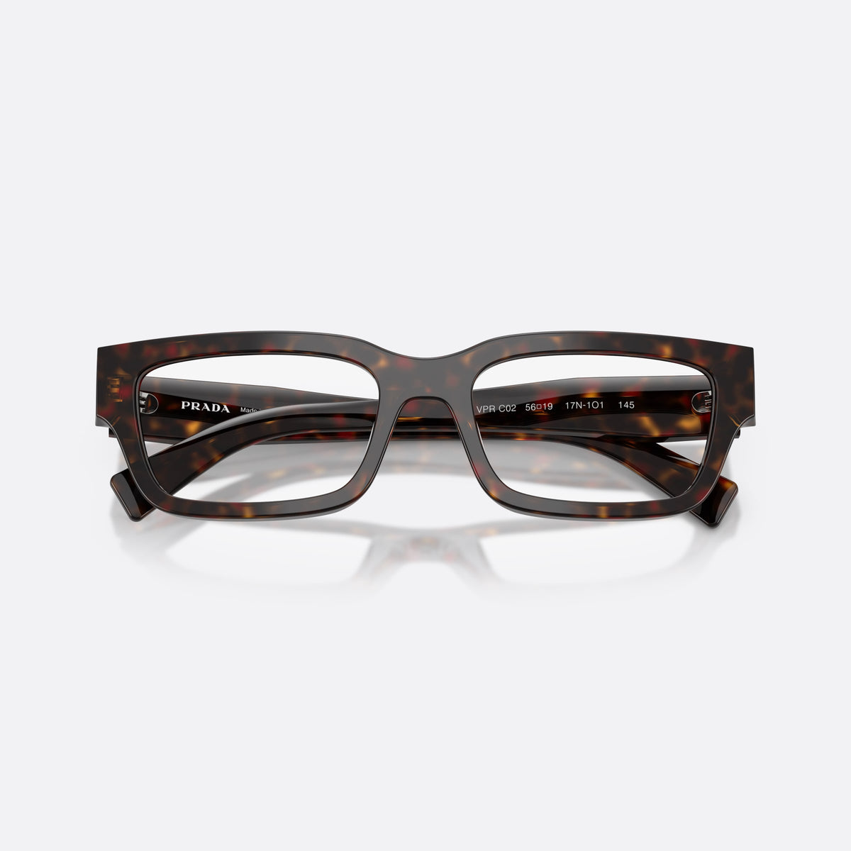 Prada PR C02V 17N1O1 eyeglasses, havana pillow frame for men, plain saddle bridge, brand logo plaque on temples, folded