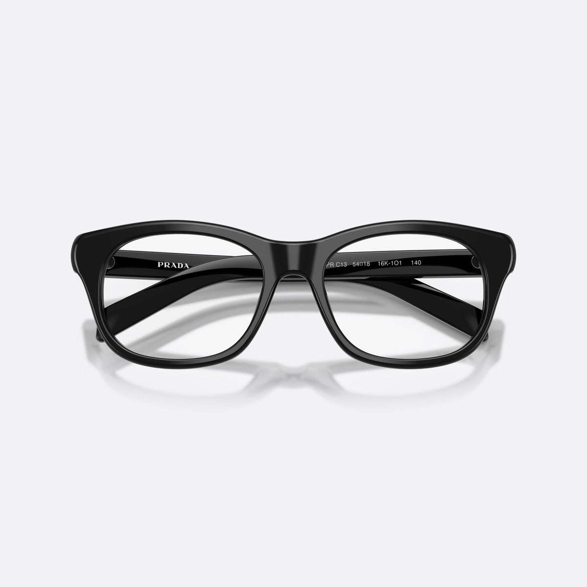 Prada PR C13V 16K1O1 eyeglasses, black pillow frame for women, plain acetate-style bridge, brand lettering on temples, folded