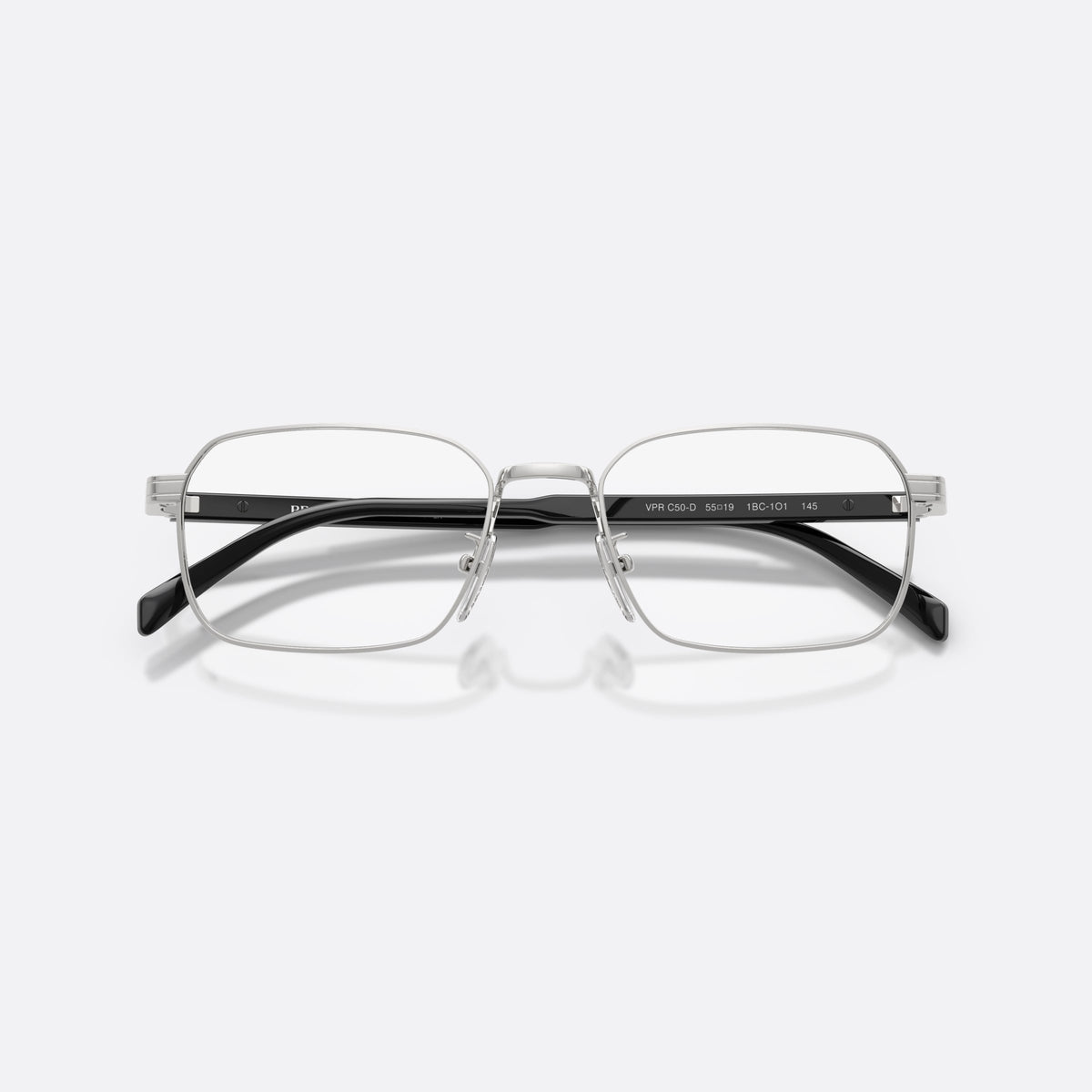 Prada PR C50VD 1BC1O1 eyeglasses, silver pillow frame for men, plain metal bridge, brand lettering on the temples, folded