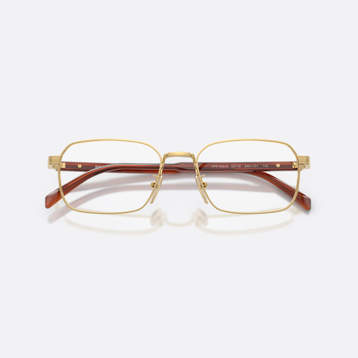 Prada PR C50VD 5AK1O1 eyeglasses, gold pillow frame for men, plain metal bridge, brand lettering on temples, folded
