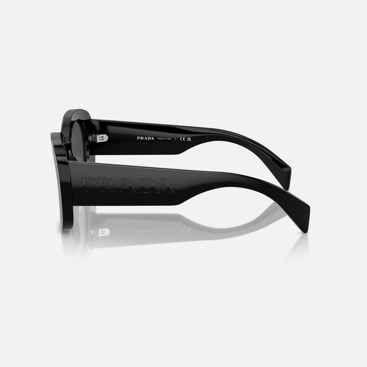 Prada PR A13S 1AB-5S0 B sunglasses, black oval frame for women, plain saddle style bridge, raised brand lettering on temples, side view