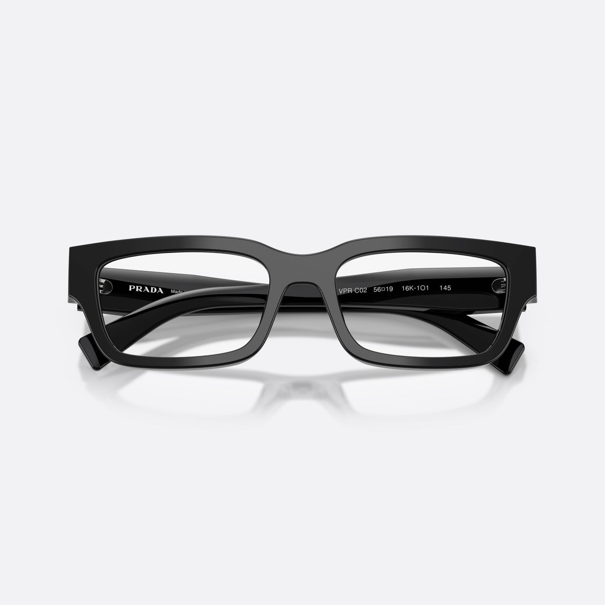 Prada PR C02V 16K1O1 eyeglasses, black pillow frame for men, plain double-arch bridge, brand lettering on temples, folded