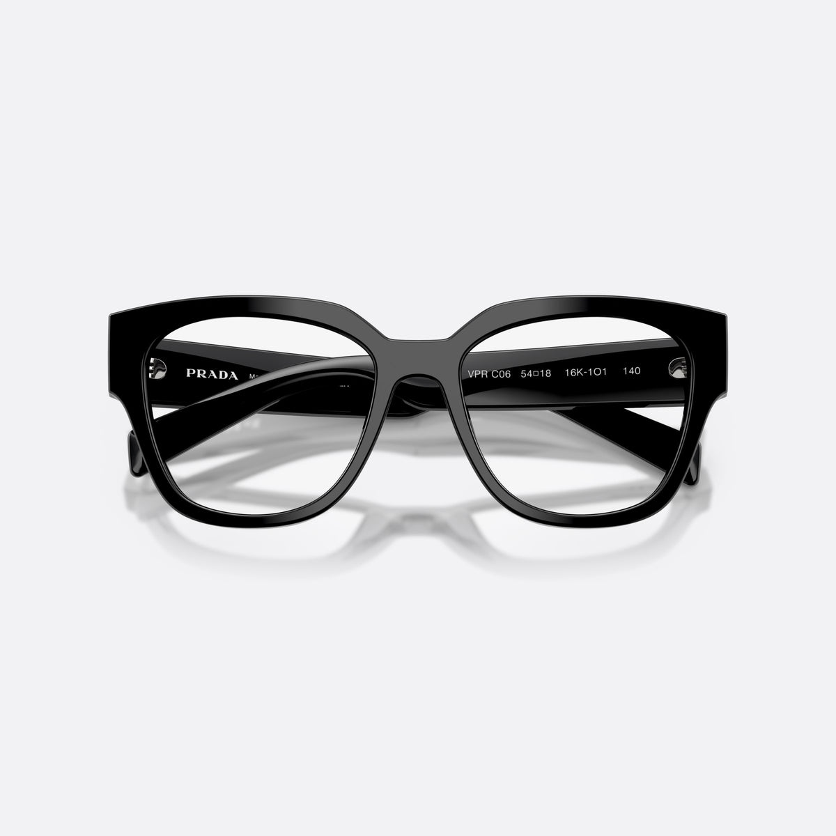 Prada PR C06V 16K1O1 eyeglasses, black oval frame for women, plain integrated bridge, brand lettering on temples, folded