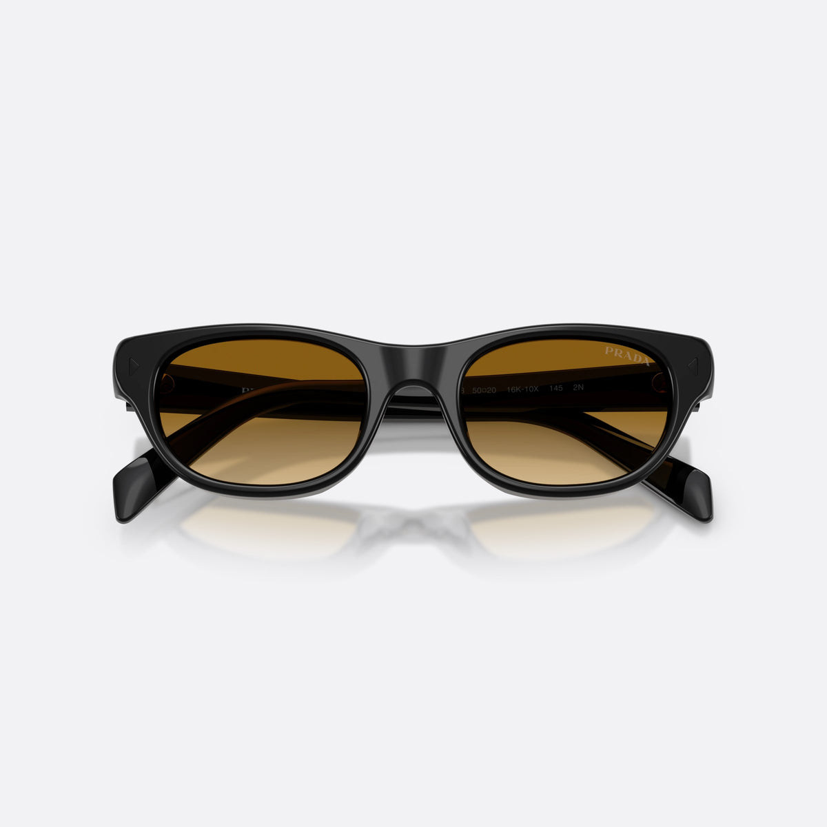 Prada PR C08S 16K10X sunglasses, black cat eye frame for women, plain integrated bridge, brand lettering on temples, folded